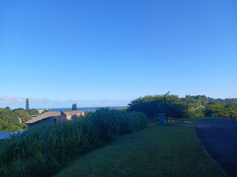 A scenic view overlooking the surrounding landscape and distant ocean horizon from the residential street level.