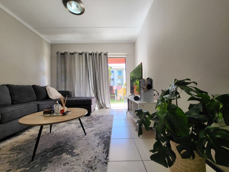 A living room featuring tiled flooring and a sliding glass door providing access to an outdoor area.