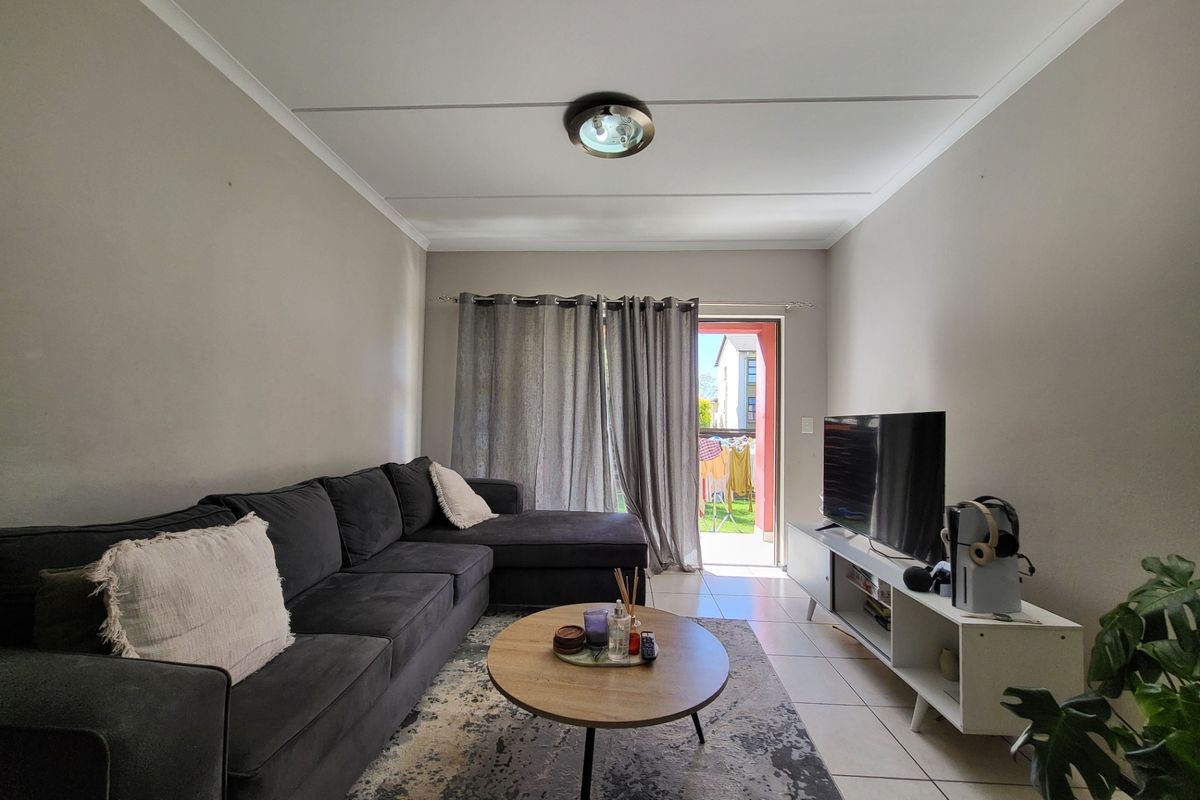 A living room featuring tiled flooring and a sliding door providing access to an outdoor area.