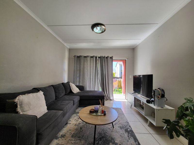 A living room featuring tiled flooring and a sliding door providing access to an outdoor area.