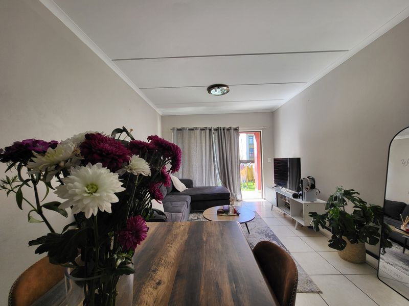 Open-plan living area featuring tiled flooring, coved ceilings, and a sliding glass door providing access to the outdoor space.
