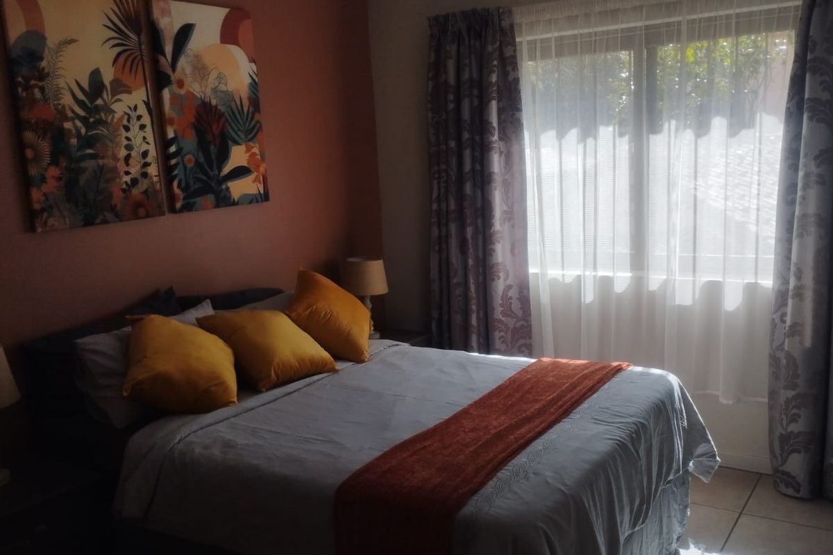 A bedroom featuring tiled flooring and natural light through a window with installed curtain tracks.