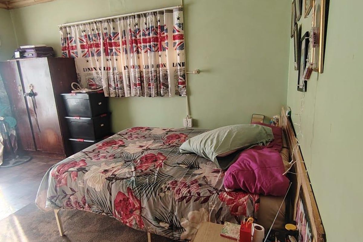 A bedroom featuring green walls, coving, and carpet flooring. The room requires cosmetic updates to improve its overall condition and appeal.