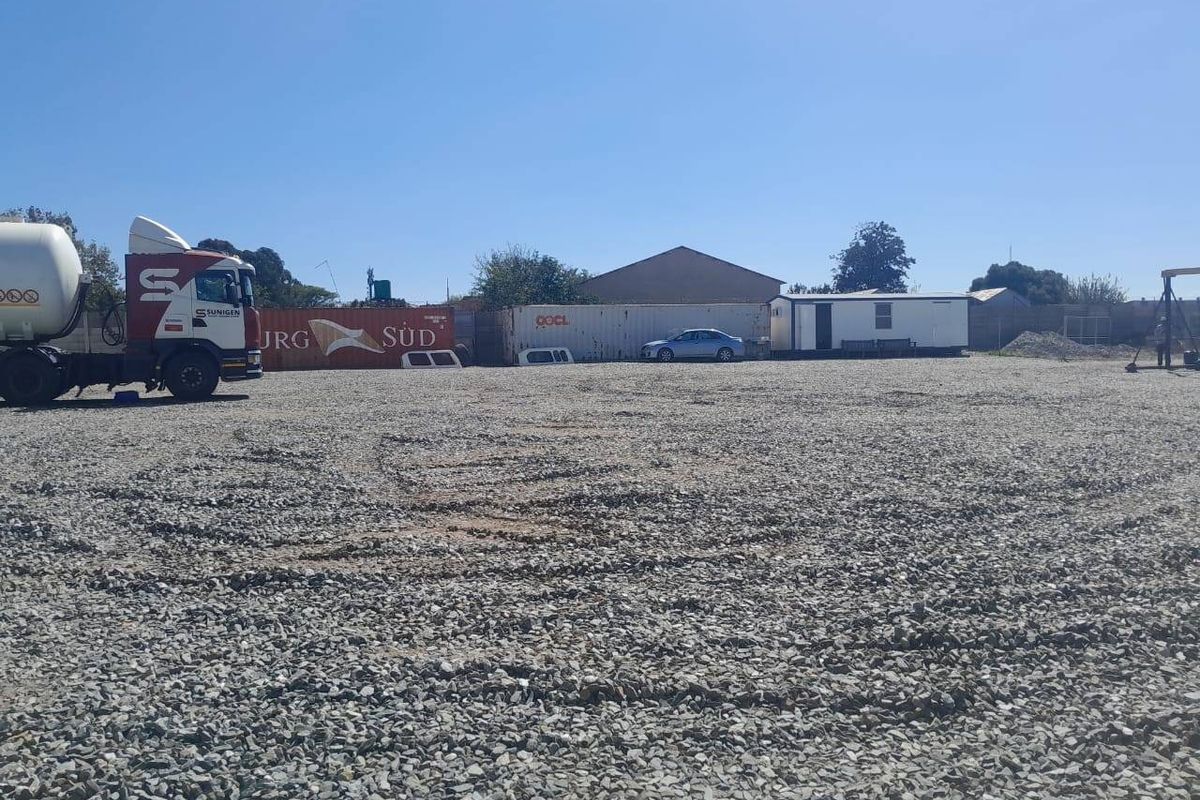 A large, open commercial yard area featuring a gravel surface, suitable for storage or industrial use.