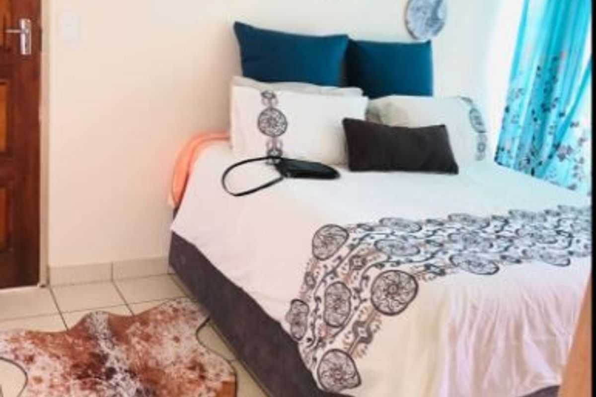 A bedroom featuring tiled flooring and a timber door, providing a functional space for rest.