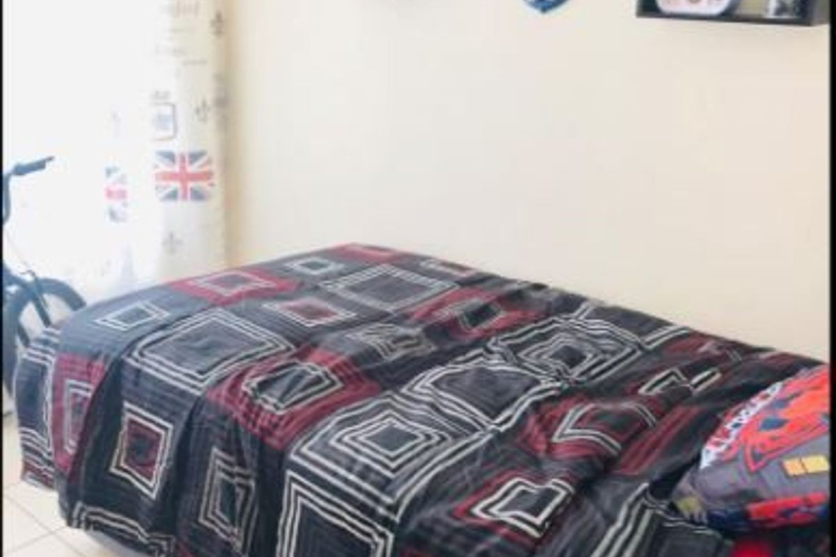 A standard bedroom featuring tiled flooring and neutral wall finishes, suitable for a single bed setup.