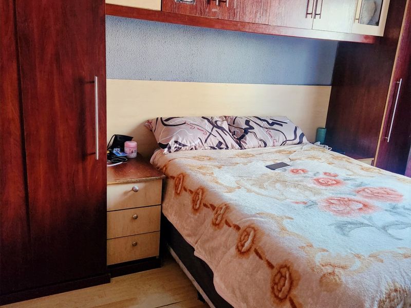 A bedroom featuring extensive built-in wooden cabinetry and overhead storage units, providing ample integrated storage space.