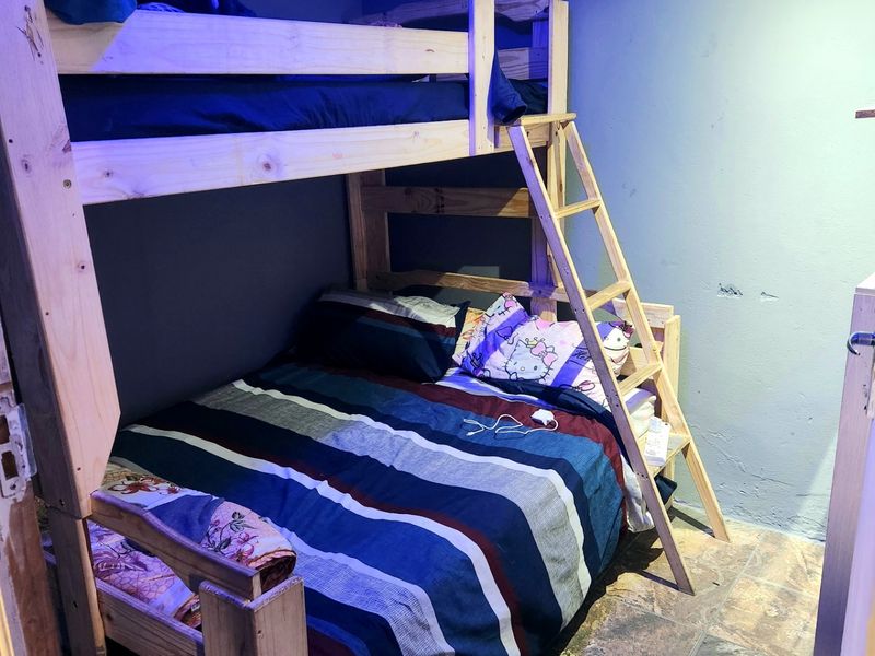 A bedroom featuring tiled flooring and decorative ceiling cornicing, currently showing signs of wall surface wear and requiring cosmetic attention.