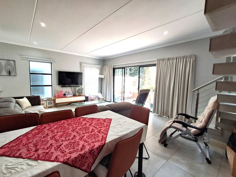 Spacious open-plan living and dining area featuring large sliding doors that provide seamless access to the outdoor patio space.