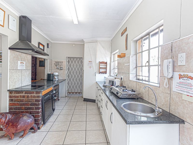Functional kitchen featuring granite countertops, built-in oven, extractor fan, and tiled finishes, offering a practical layout for daily meal preparation.
