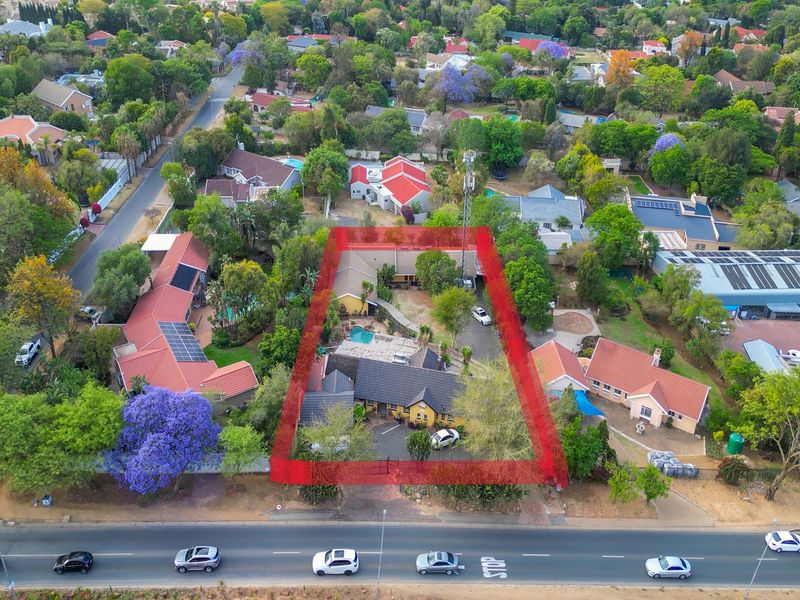 Aerial view of the residential property highlighting the building layout, swimming pool, and surrounding garden area within the established neighborhood.