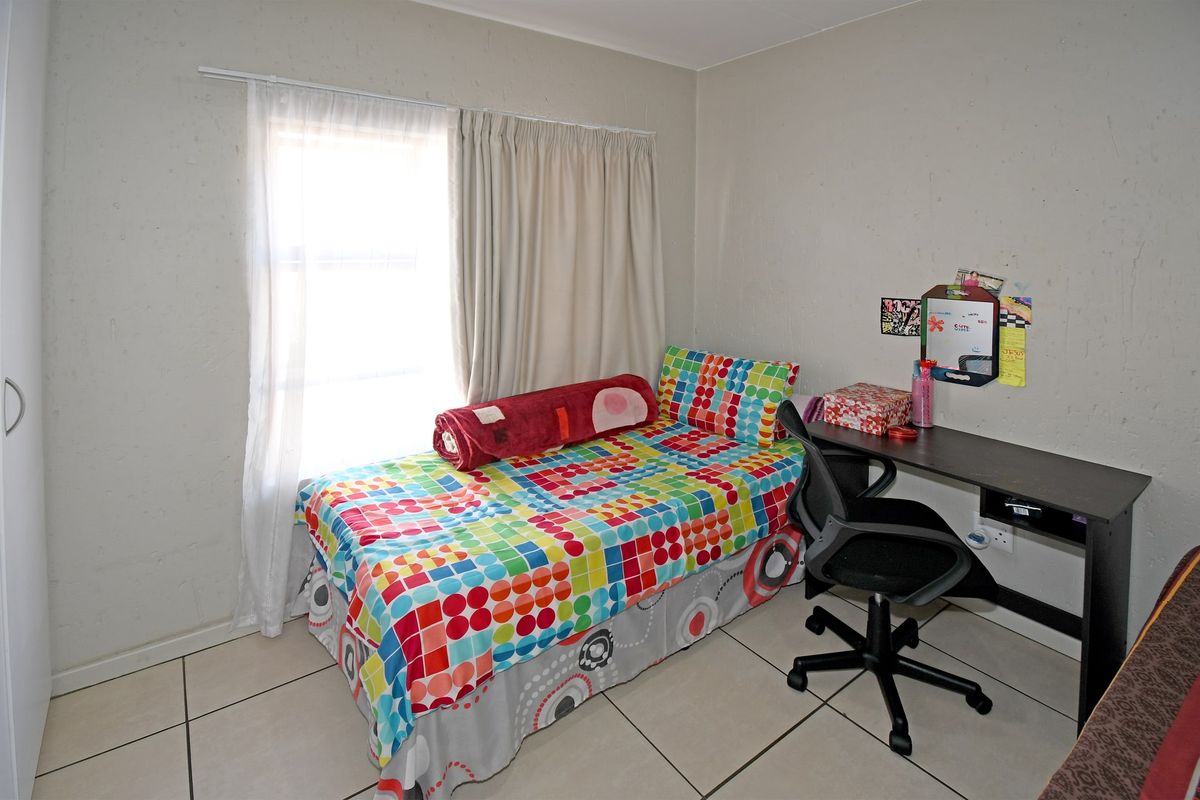 A functional bedroom featuring tiled flooring and a built-in wardrobe, offering a neutral base for personalization.