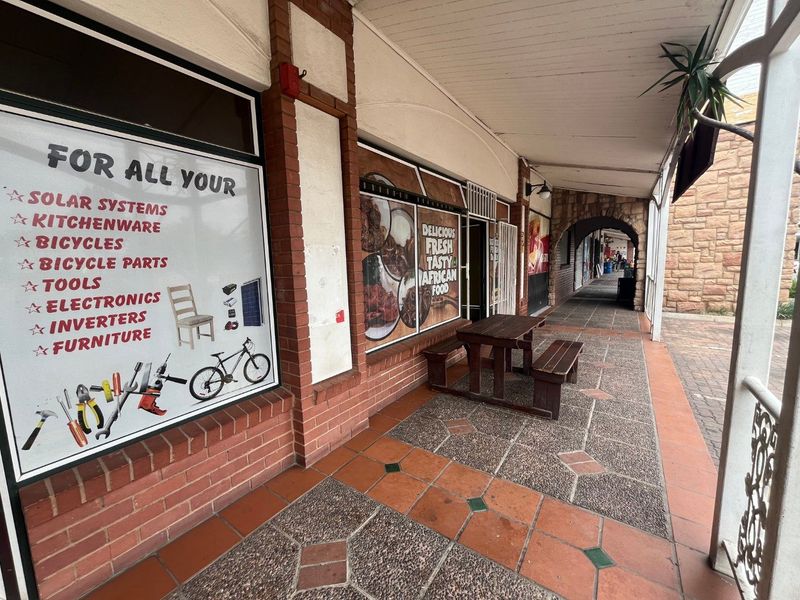 Commercial storefront featuring a covered veranda, brick and stone facade, and large display windows suitable for retail or food service operations.