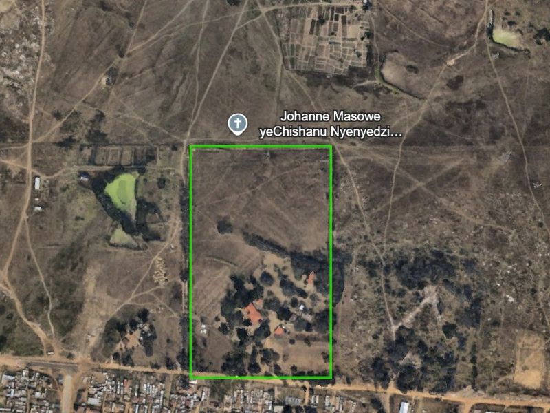 Aerial view of a farm property showing the land boundaries, surrounding landscape, and existing structures on the plot.