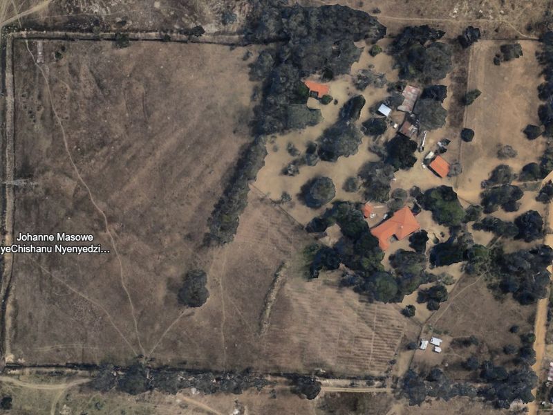 Aerial view of a large farm property featuring a main dwelling, multiple outbuildings, and extensive open land with mature trees.