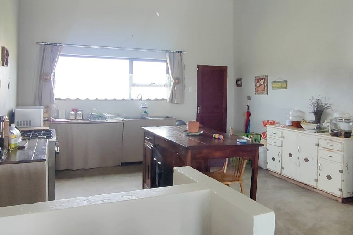 A spacious kitchen area featuring a central island, built-in cabinetry, and a large window providing natural light.