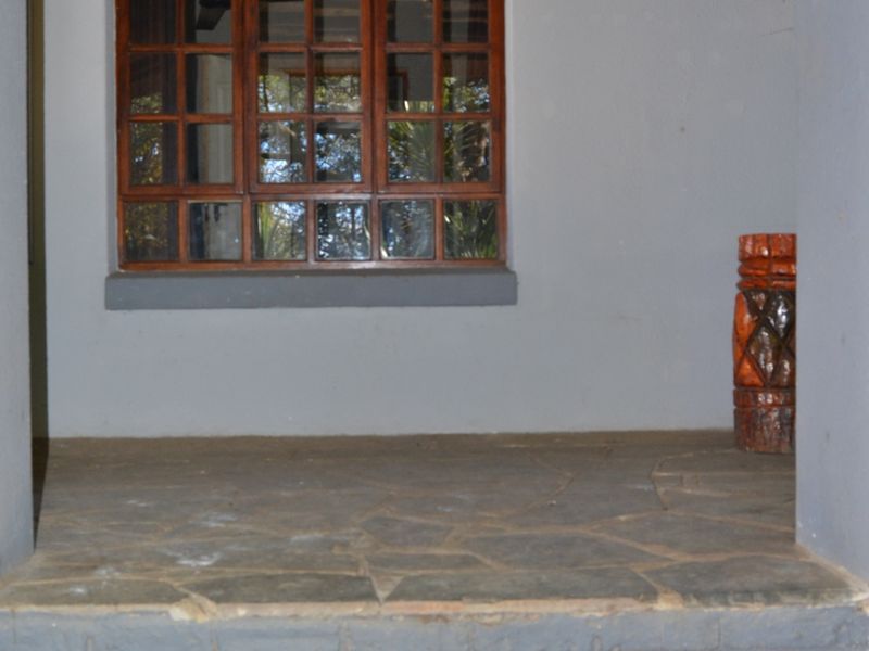 Entrance area featuring stone-paved flooring, tiled steps, and a timber-framed window.