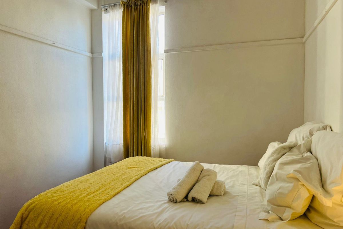 A simple bedroom featuring a window with a curtain rail, providing natural light to the space.