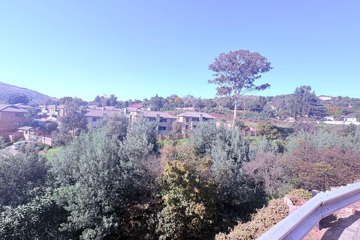 A scenic elevated view overlooking a residential complex surrounded by lush greenery and trees.