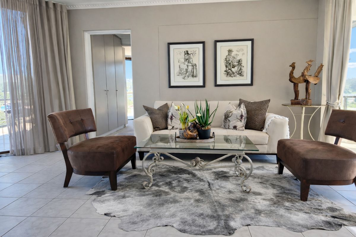A well-maintained living room featuring neutral tiled flooring, built-in storage cupboards, and large sliding glass doors that provide ample natural light.