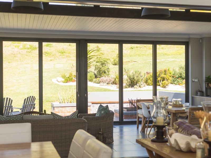 Spacious open-plan living area featuring large sliding glass doors that provide seamless indoor-outdoor flow to the garden and patio area.