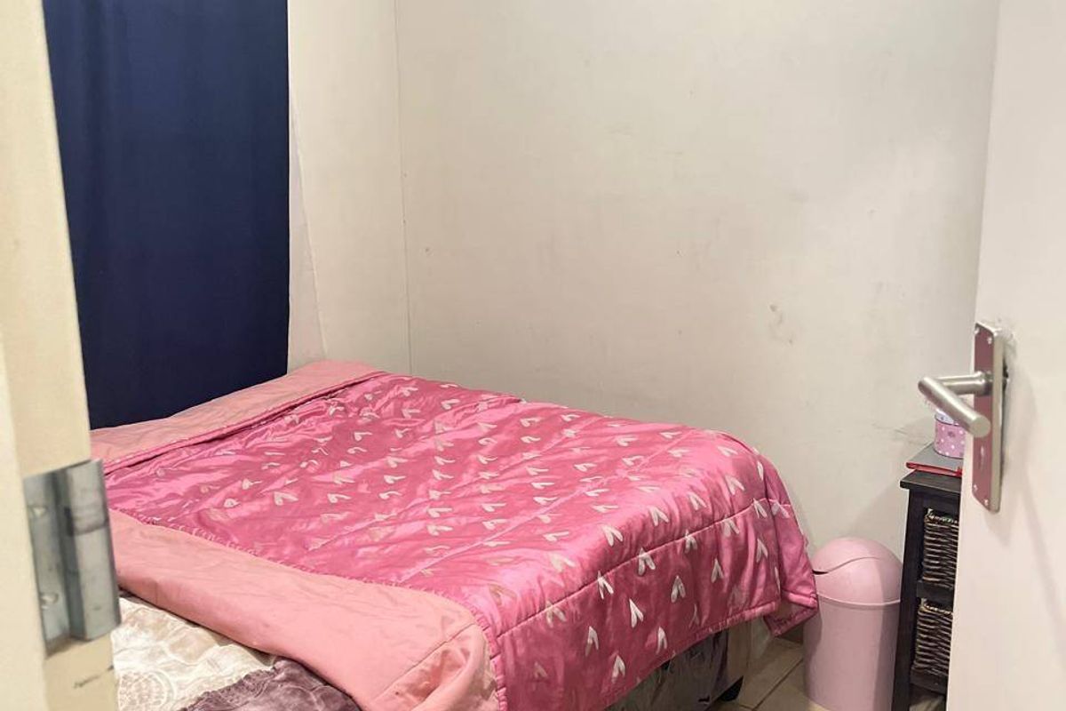 A compact bedroom featuring tiled flooring and neutral wall finishes, offering a functional space ready for cosmetic updates.