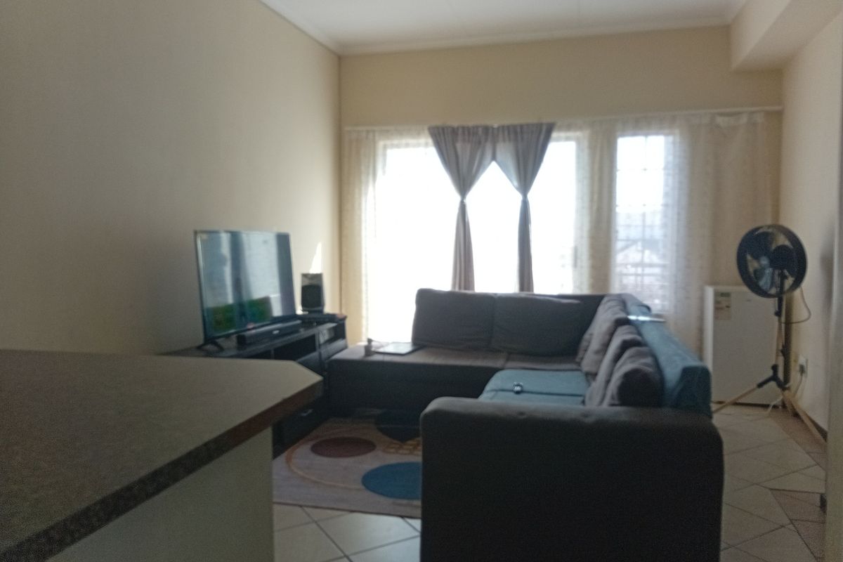 A living room area featuring tiled flooring and a sliding glass door providing natural light.