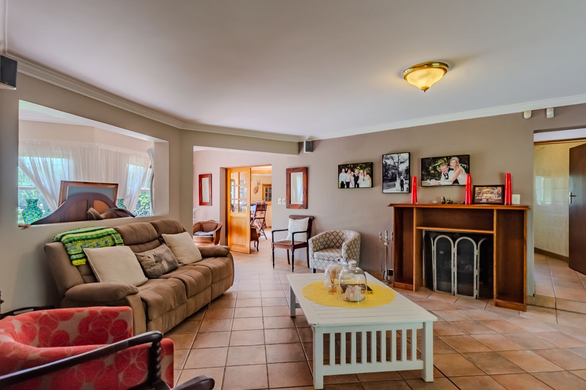 Spacious living room featuring tiled flooring, a built-in fireplace with a timber mantel, and direct access to adjacent living areas.