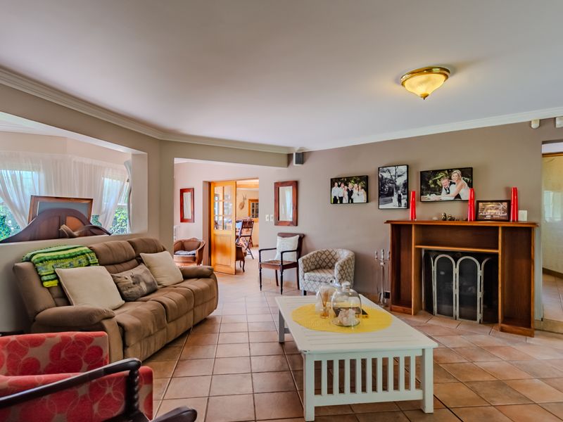 Spacious living room featuring tiled flooring, a built-in fireplace with a timber mantel, and direct access to adjacent living areas.