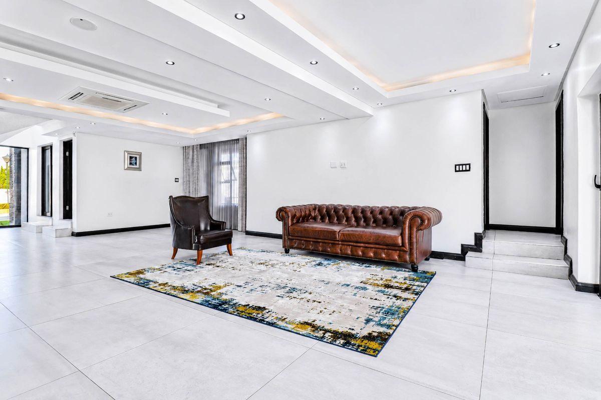 Spacious living area featuring a modern coffered ceiling with recessed lighting, ducted air conditioning, and large format floor tiles.