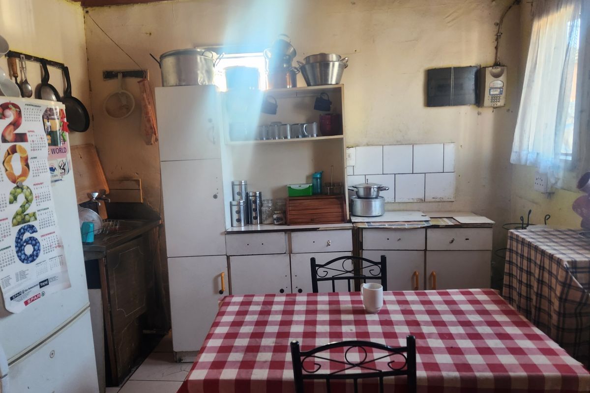 A dated kitchen featuring original built-in cabinetry, tiled splashback, and timber ceiling, offering significant potential for modernization and renovation.
