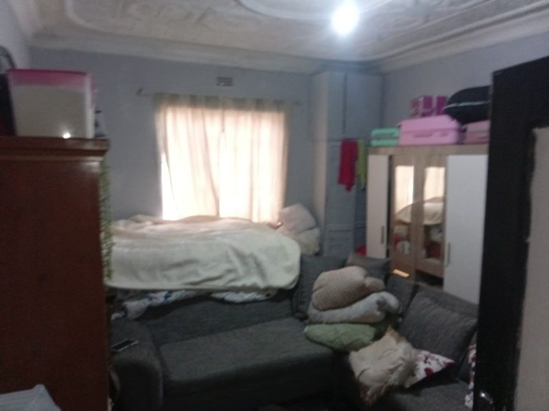 A bedroom featuring built-in cupboards and decorative ceiling molding, currently used as a multi-purpose living space.