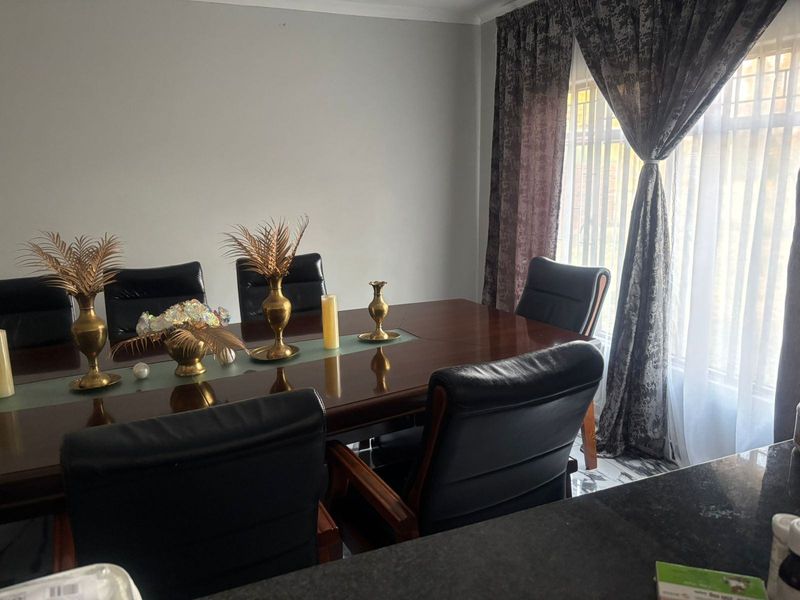 A dining room area featuring tiled flooring and window treatments, providing a functional space for family meals and entertaining.