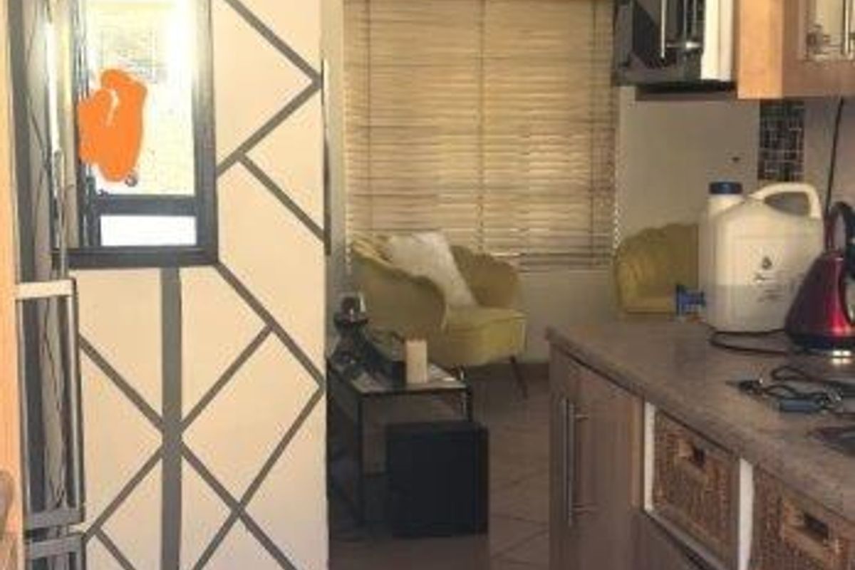 A compact kitchen featuring built-in cabinetry and tiled flooring, showing signs of wear and requiring cosmetic updates to improve the overall aesthetic.