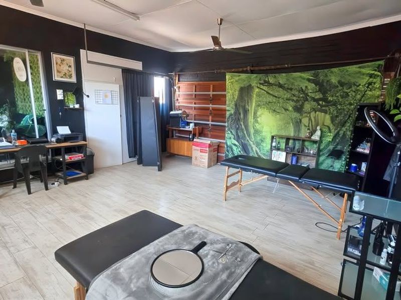 A multi-purpose room featuring wood-look tile flooring, a ceiling fan, and a large sliding glass door providing access to an adjacent space.