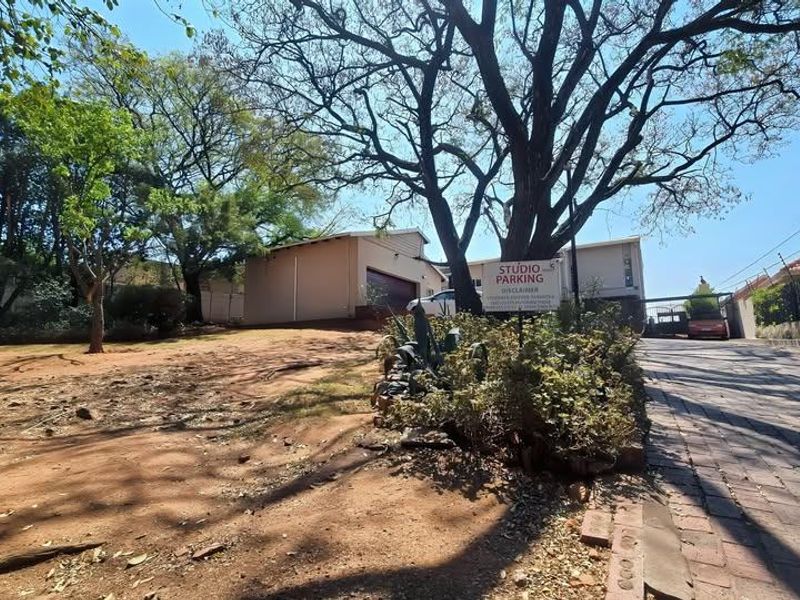 Exterior view of the property entrance featuring a paved driveway, garage access, and perimeter electric fencing.