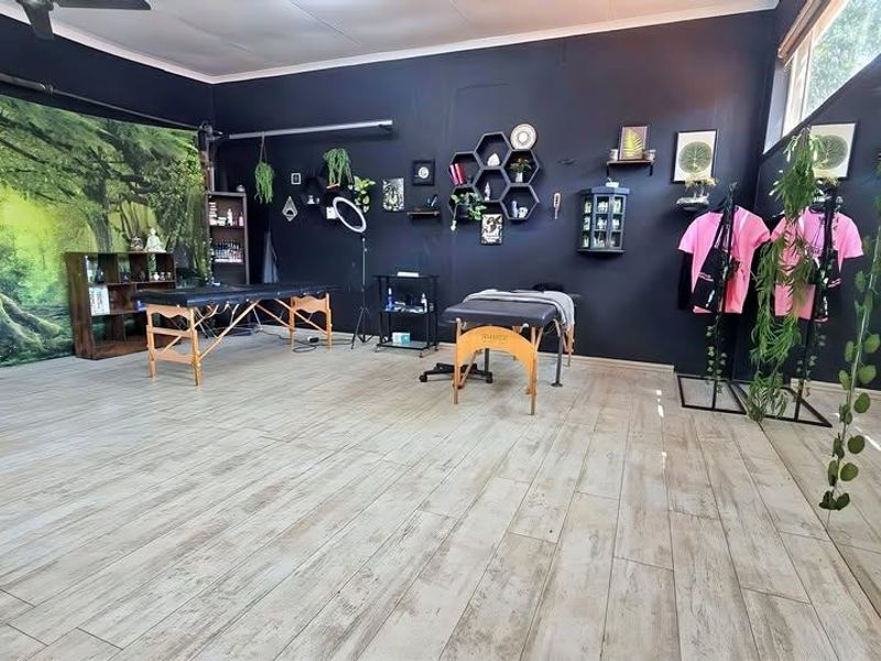 A versatile utility space featuring wood-look tile flooring and a ceiling fan, currently utilized as a professional studio area.