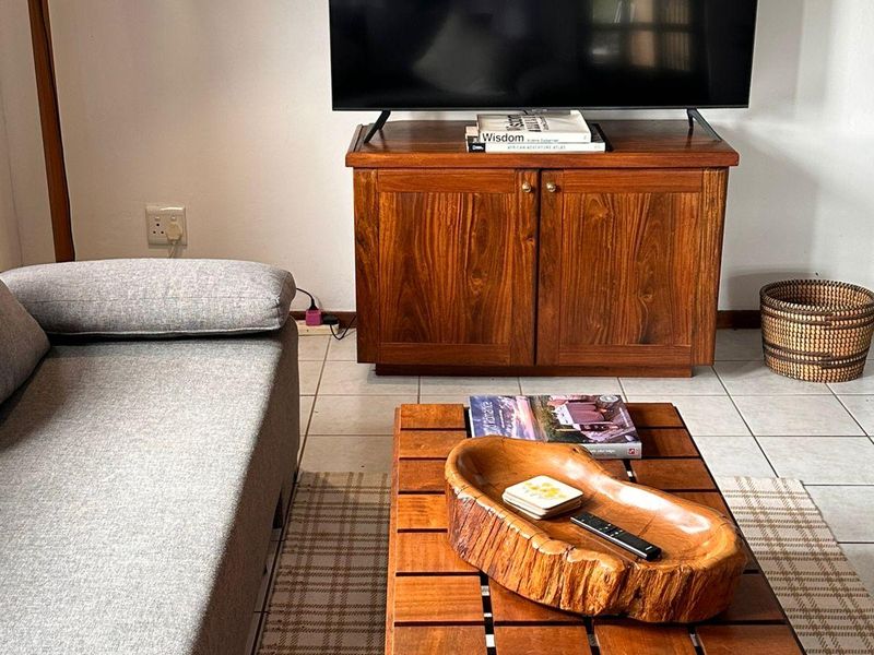 A living room area featuring neutral tiled flooring and standard electrical fixtures, providing a functional and comfortable space for relaxation.