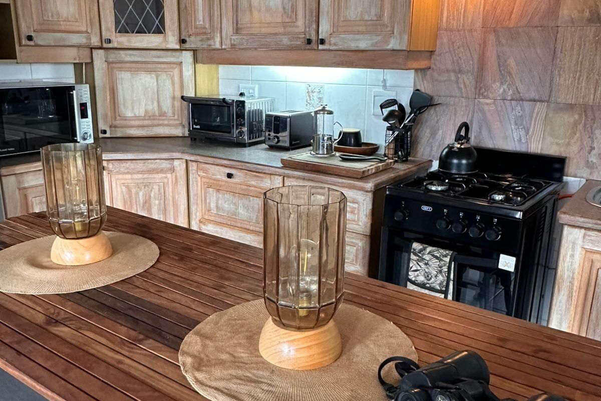 A rustic-style kitchen featuring wooden cabinetry, stone tile backsplash, and a gas stove, offering a warm and traditional aesthetic.