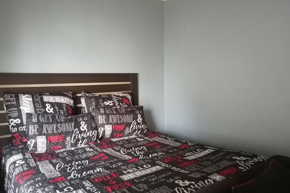 A bedroom featuring neutral grey walls and decorative ceiling cornicing.