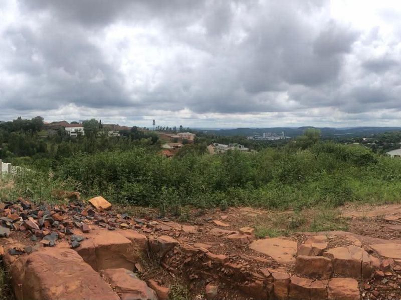 A panoramic view of the surrounding residential landscape and natural terrain from the vacant residential plot.