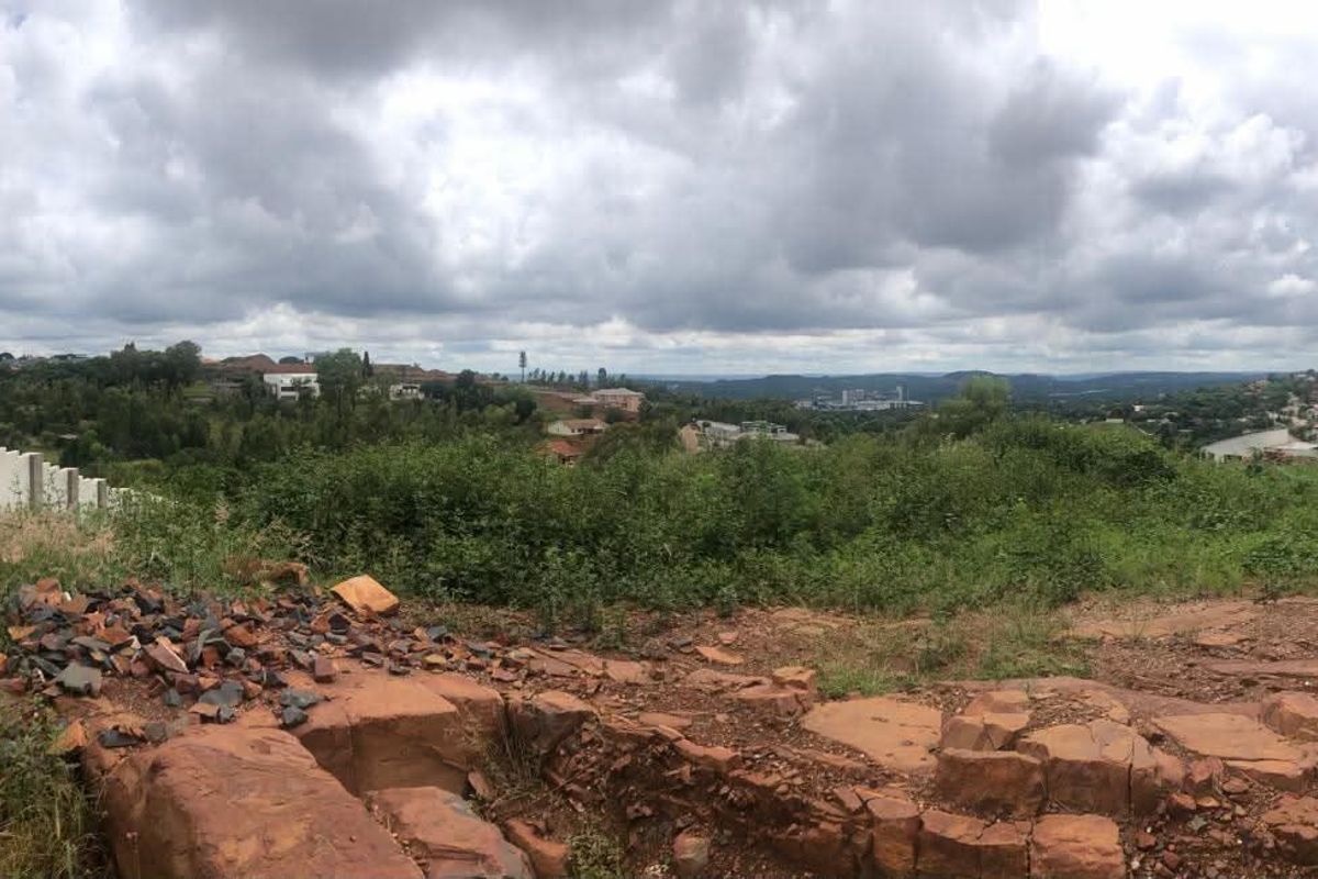 A panoramic view of the surrounding residential landscape and natural terrain from the vacant residential plot.