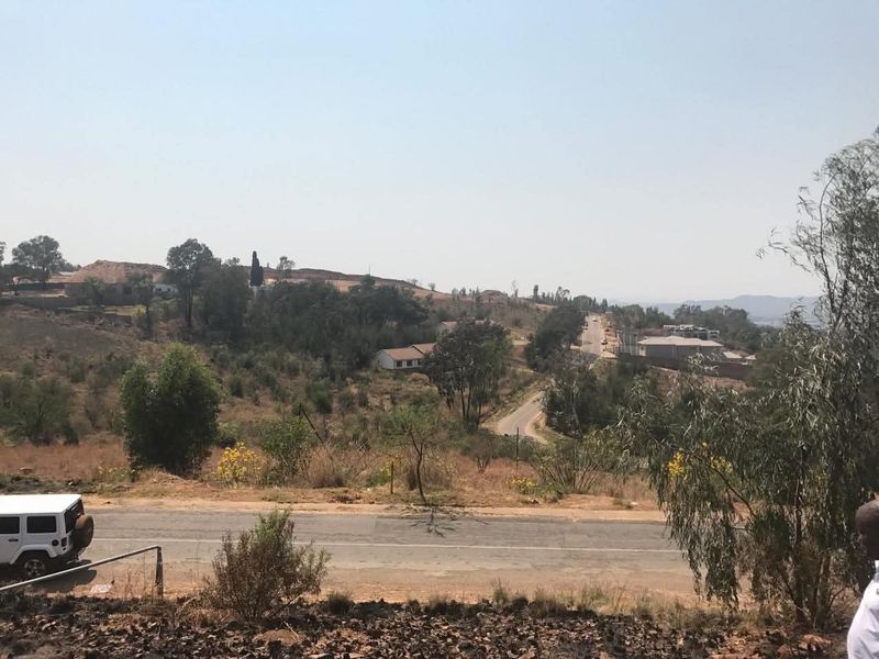 A wide-angle view of the surrounding landscape, featuring local roads, natural vegetation, and distant residential properties.