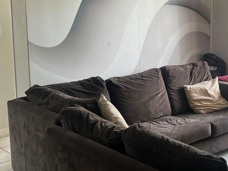 A living room area featuring neutral tiled flooring and a large-scale abstract wave-patterned feature wall.