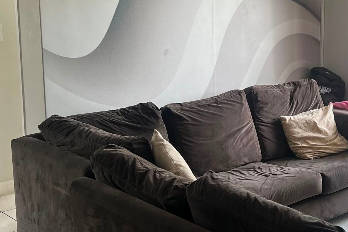 A living room area featuring neutral tiled flooring and a large-scale abstract wave-patterned feature wall.