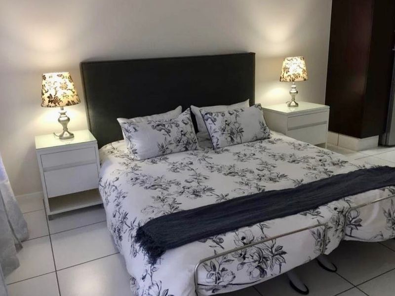 A well-lit bedroom featuring neutral wall finishes and clean tiled flooring, providing a comfortable and functional sleeping space.