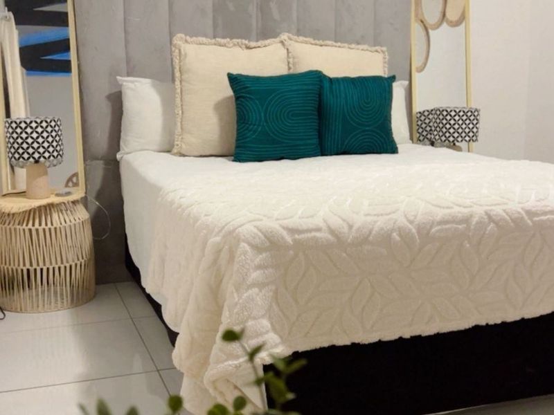A well-presented bedroom featuring tiled flooring and a modern upholstered headboard, creating a comfortable and inviting sleeping space.