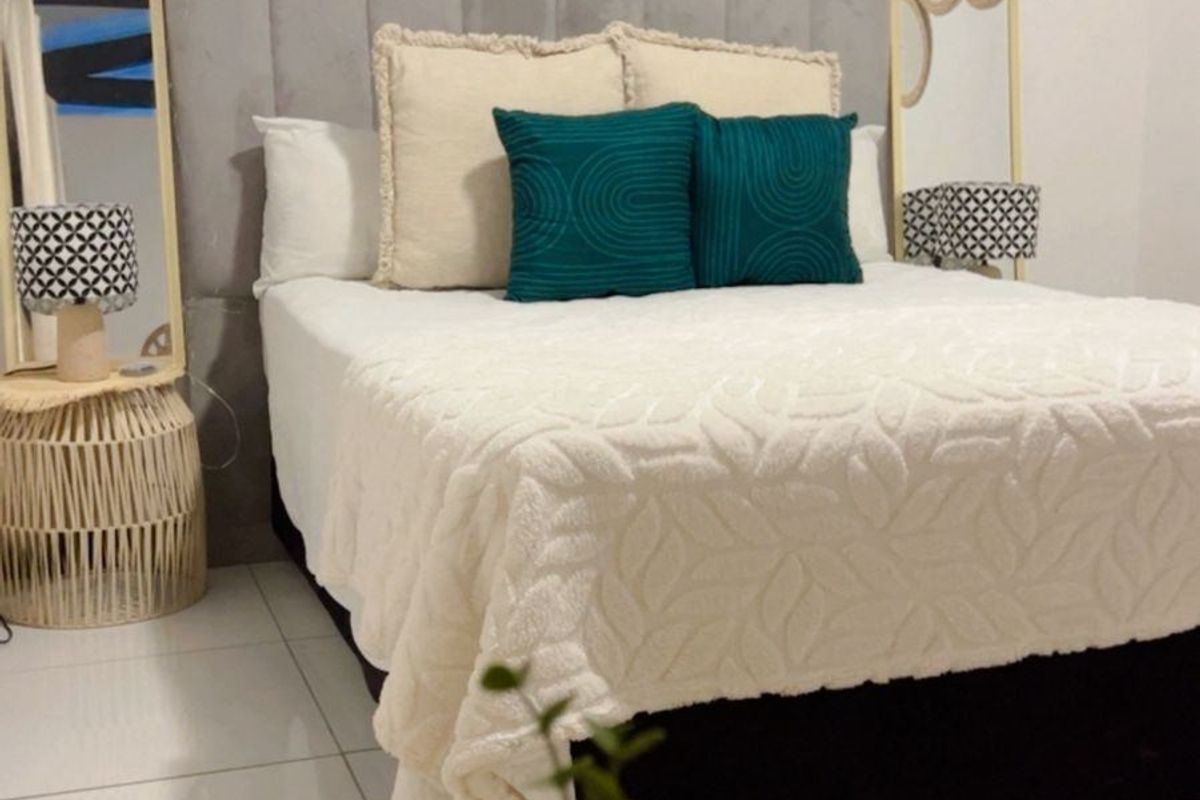 A well-presented bedroom featuring tiled flooring and a modern upholstered headboard, creating a comfortable and inviting sleeping space.