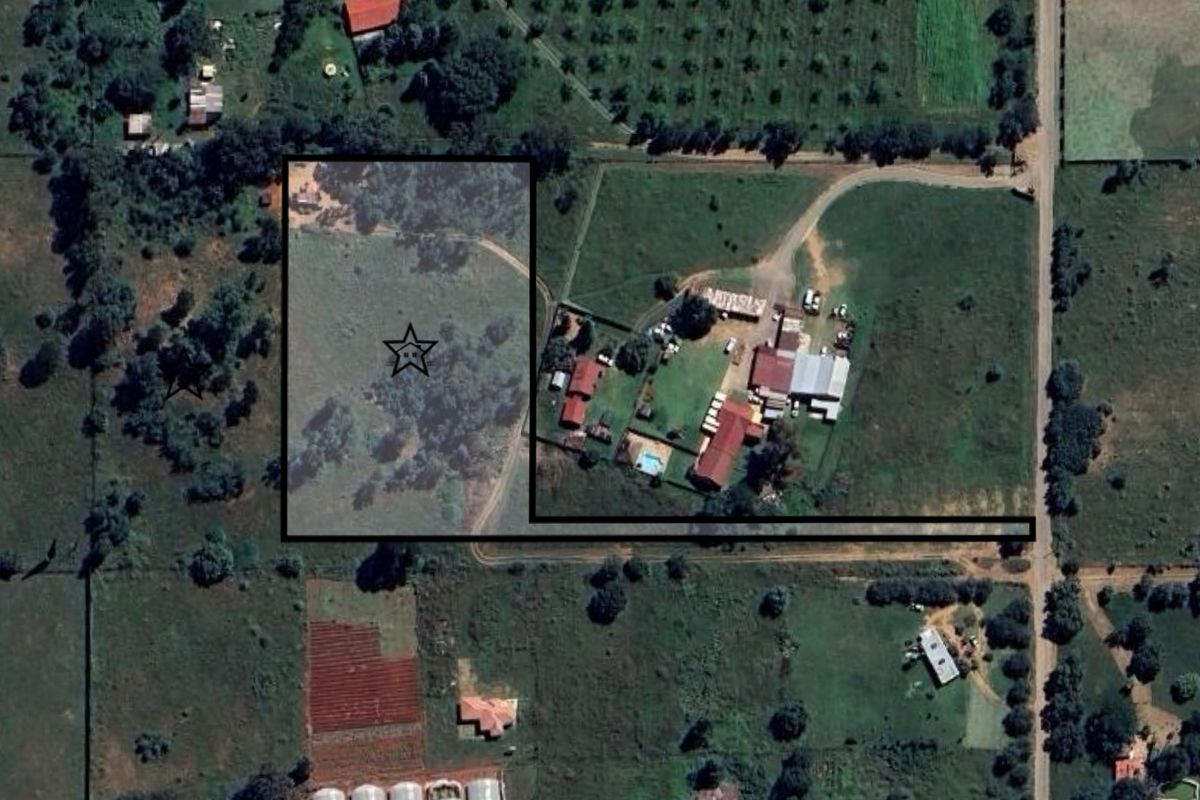 Aerial view of a vacant residential land parcel with surrounding rural landscape and access road.