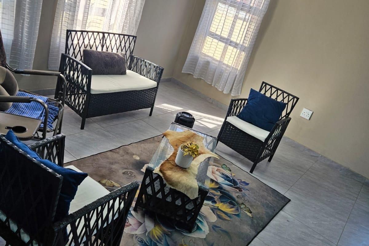 A bright living room featuring large windows with sheer curtains, modern tiled flooring, and decorative recessed ceiling lighting.